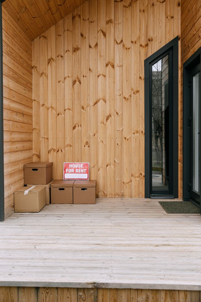 Mastering the First Impression: Your intriguing post title goes here A wooden porch with boxes and 'House for Rent' sign, perfect for real estate listings.